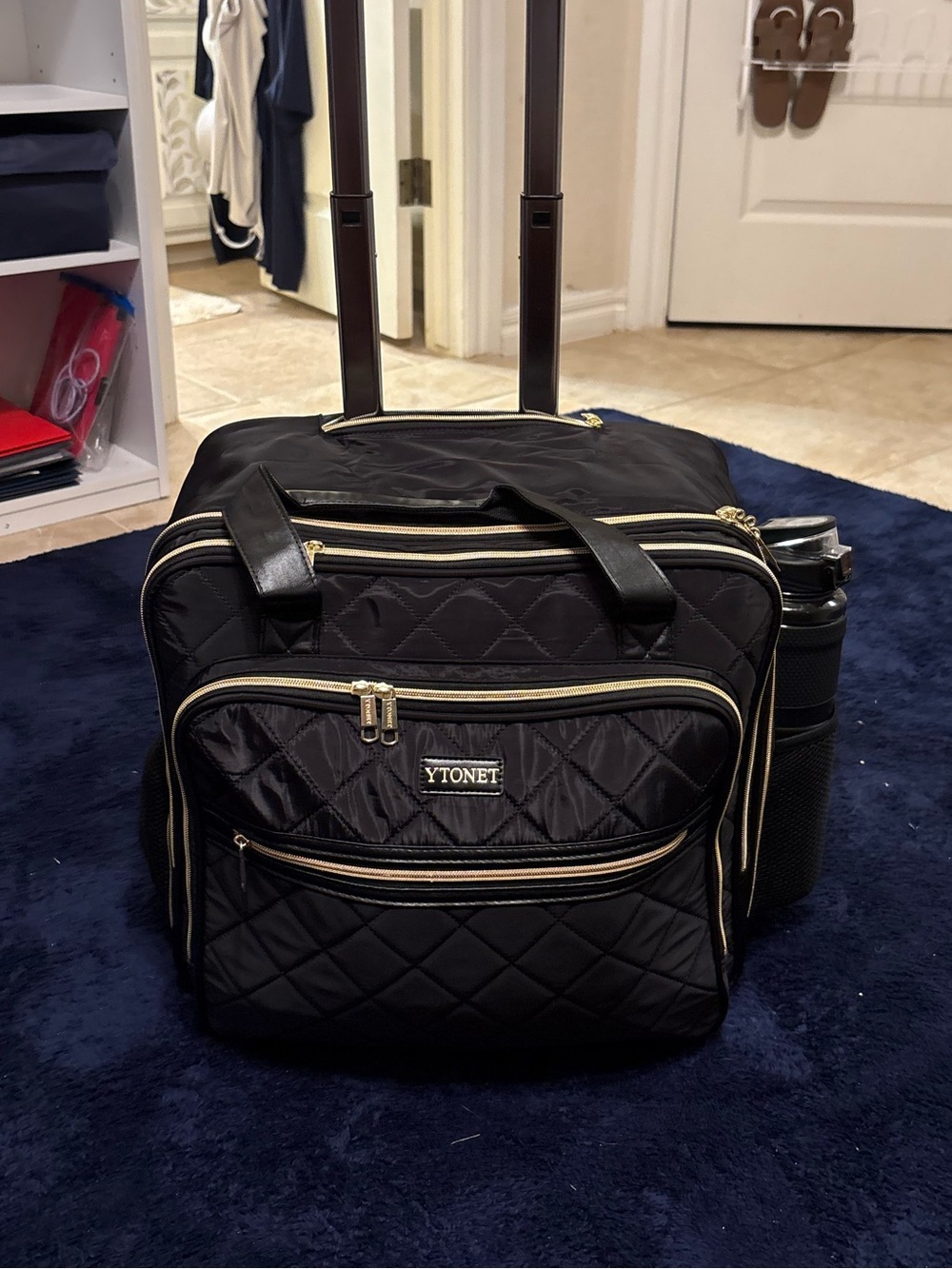 Black Quilted Rolling Travel Bag with Gold Accents
